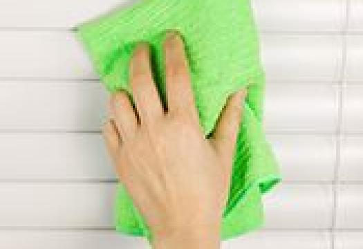 Cleaning blinds with green cloth