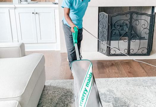 Merry Maids Team Member vacuuming a home.