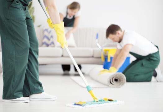 Cleaning professionals doing a thorough job mopping floors and vacuuming upholstery at a residence. | Merry Maids®