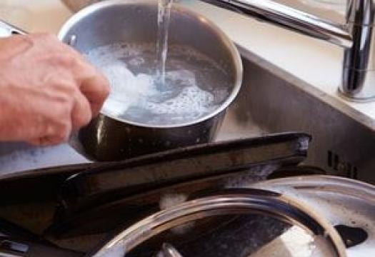 cleaning pots and pans in the sink