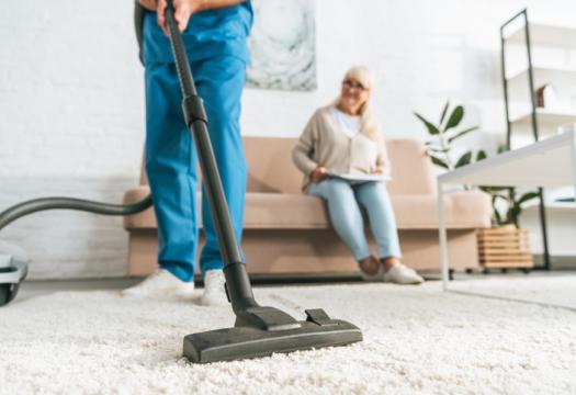 Professional cleaner vacuuming for an elderly woman | Merry Maids