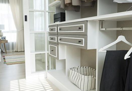 Organized white and grey closet with few clothes hanging | Merry Maids