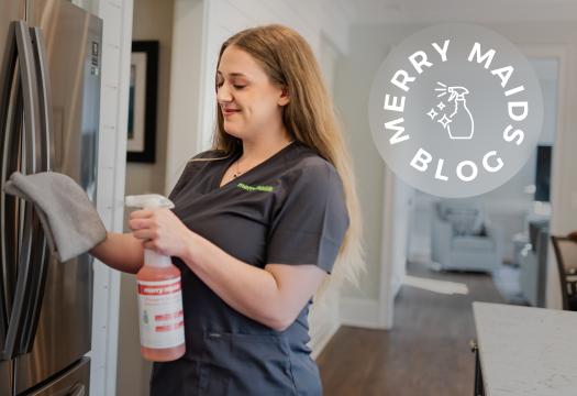 Merry Maids cleaner cleaning fridge