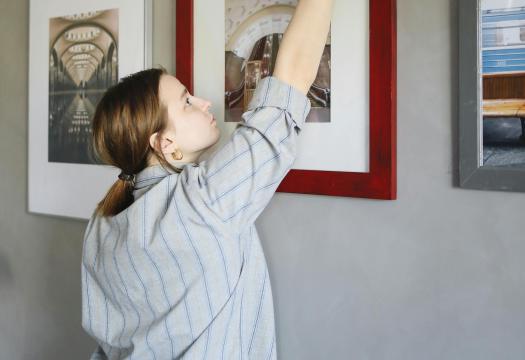 woman dusting a picture frame