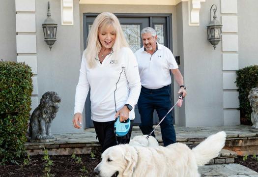 Couple outside home with dog